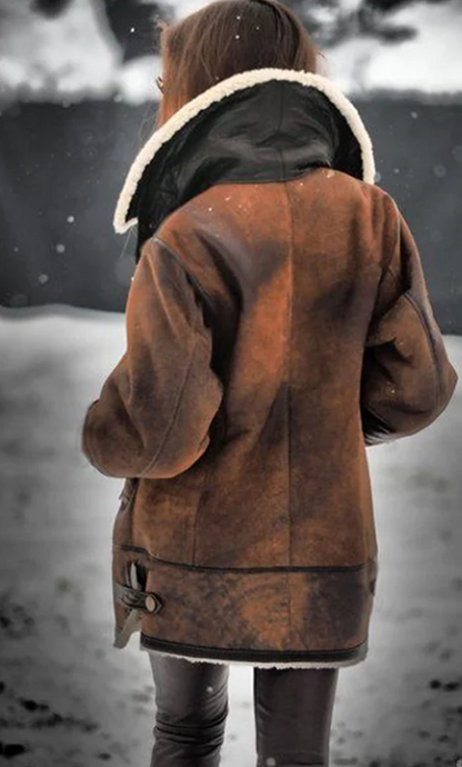 Frau in brauner Lederjacke mit Fellkragen im Schnee, Wintermode, stilvoll, warm, Outdoor-Bekleidung.