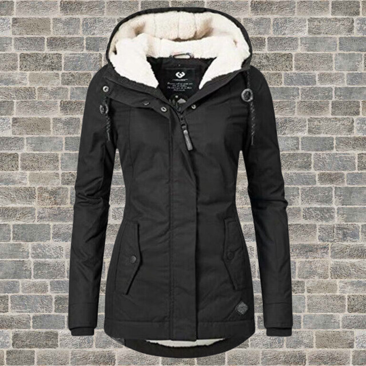 Schwarze Damen-Winterjacke mit Kapuze, warm gefüttert, vor Ziegelwand.