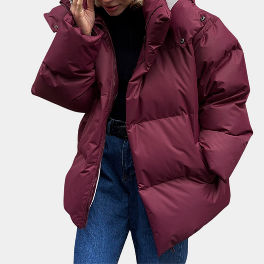 Frau in weinroter Daunenjacke, Wintermode, warme Oberbekleidung, stilvoll, bequem.