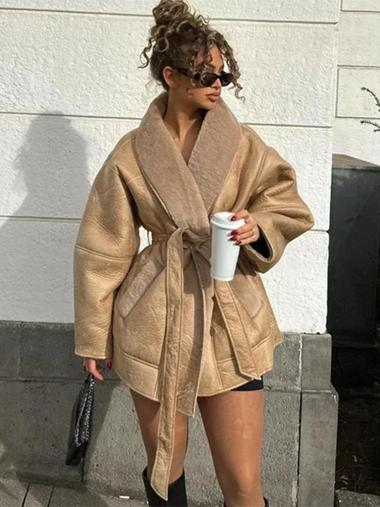 Frau in beigem Kunstledermantel mit Gürtel, Sonnenbrille, Kaffeetasse, modisch, urban.
