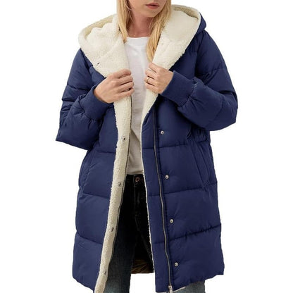 Frau in blauer Daunenjacke mit Kapuze und weißem Futter, Wintermode, warm, stilvoll.