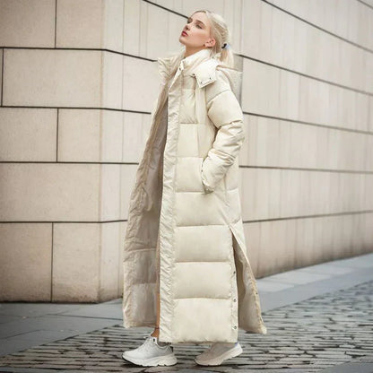 Frau in langem, beigem Daunenmantel, Wintermode, urbaner Hintergrund, stilvoll, warm.