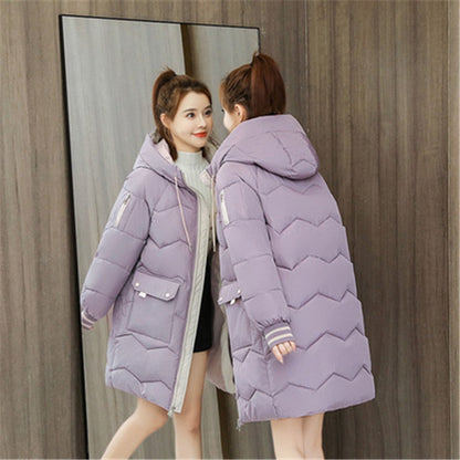 Frau in lila Daunenjacke mit Kapuze vor Spiegel, Wintermode, warme Damenbekleidung.