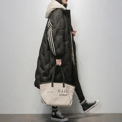 Frau in schwarzem Daunenmantel mit Kapuze, trägt beigen "Hello Paris" Shopper, lässiger Stil.