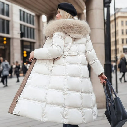 Frau in weißem Daunenmantel mit Fellkragen, Wintermode, Stadt, elegant, warm, stilvoll.