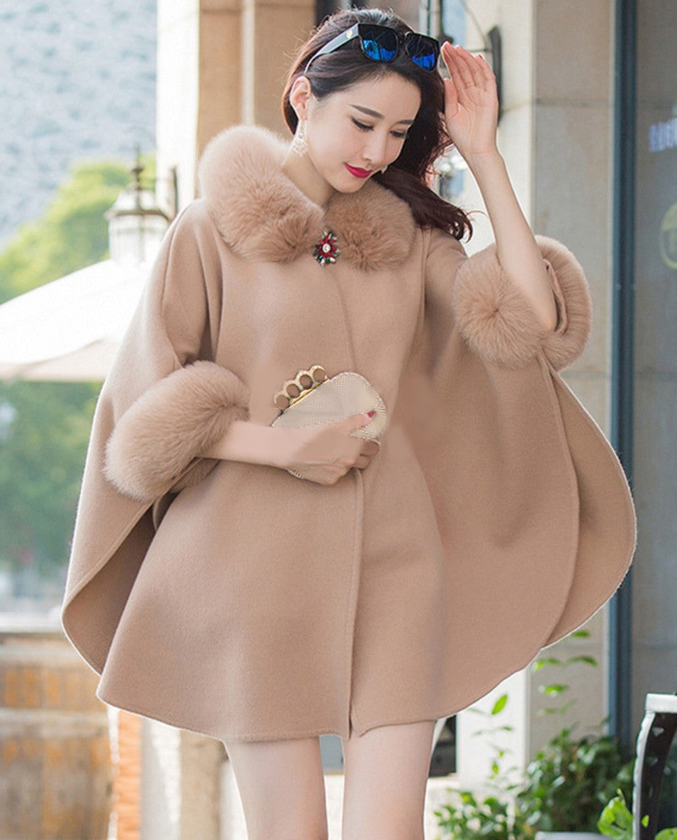 Frau in beigem Wollcape mit Pelzbesatz, elegantes Design, Modeaccessoire, Herbstbekleidung.