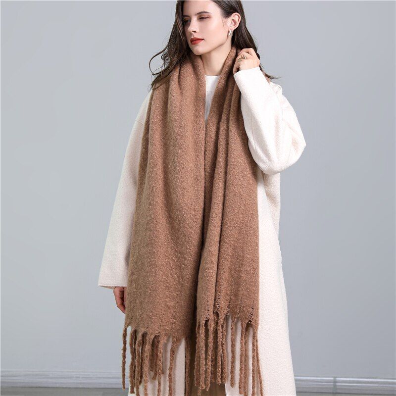 Frau mit braunem Wollschal, Fransen, elegantes Winteroutfit, modisch, warm, Damenaccessoire.