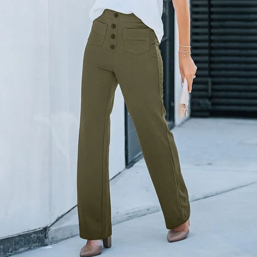 Frau in olivgrüner Hose mit Knöpfen, weißem Oberteil, hält eine Clutch, modisch, urban.