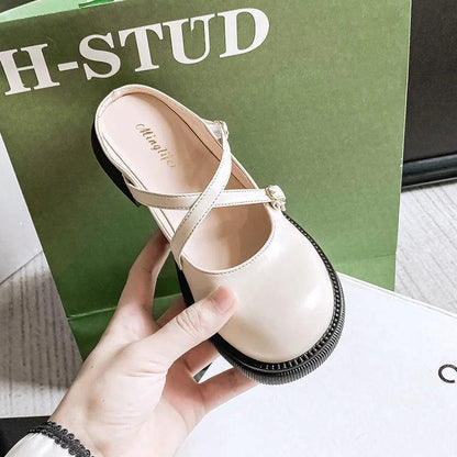 Damen-Lederslipper beige, modisch, bequem, mit Riemen, auf grünem Hintergrund.