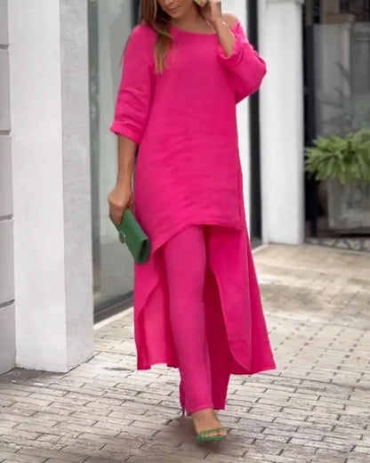 Frau in pinkem Kleid und Hose, hält grüne Clutch, modisch, elegant, Sommermode, Straße.