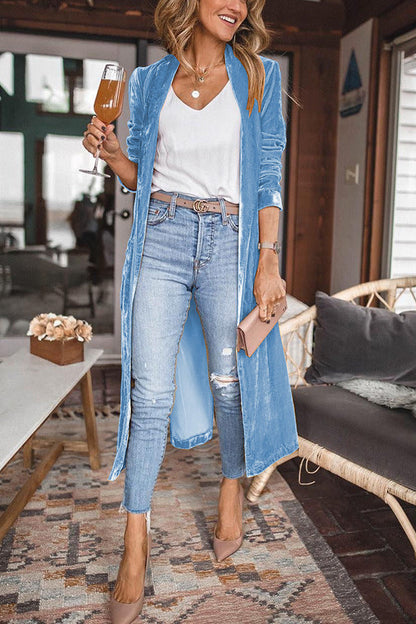 Frau in hellblauem Cardigan, Jeans, weißem Top, hält Weinglas, modisch, lässiger Stil.