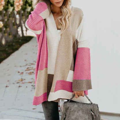 Frau in stilvollem, komfortablem Damenpullover mit Muster, rosa und beige, Herbstmode.