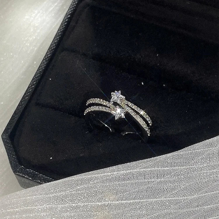 Silberner Diamantring mit Sternmotiv in schwarzer Schmuckschatulle, elegantes Design.