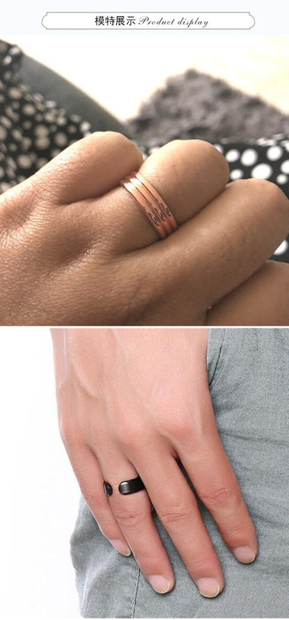 Zwei Ringe an Händen, einer aus roségoldfarbenem Metall, der andere schwarz, modisches Accessoire.