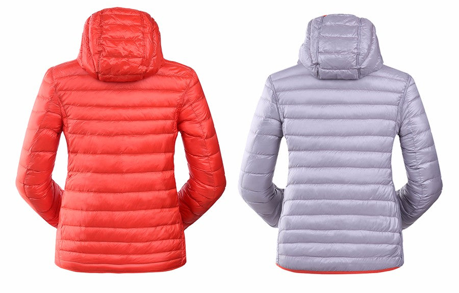 Rote und graue Daunenjacken mit Kapuze, Damenmode, Winterbekleidung, isoliert auf weißem Hintergrund.