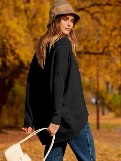 Frau mit schwarzem Pullover, Jeans und beigem Hut im Herbstpark, hält weiße Tasche.