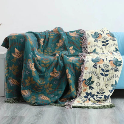 Zwei bunte Decken mit Vogel- und Blumenmuster auf Sofa, Baumwolle, Wohnzimmer-Dekoration.