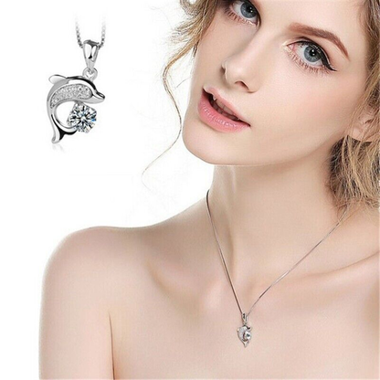 Frau mit silbernem Delfin-Anhänger, Zirkonia, eleganter Schmuck, modisches Accessoire.