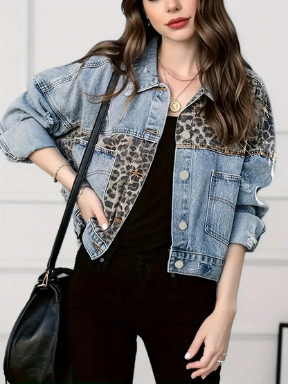 Frau in blauer Jeansjacke mit Leopardenmuster, schwarze Hose, schwarze Tasche, modisch.