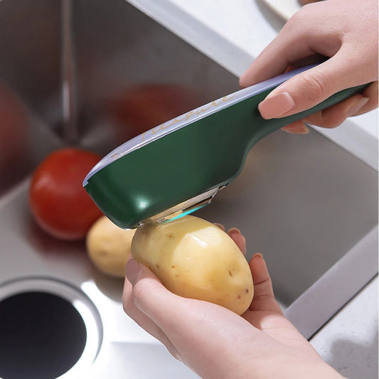 Grüner Edelstahl-Gemüseschäler mit Behälter, schält Kartoffeln in der Küche.