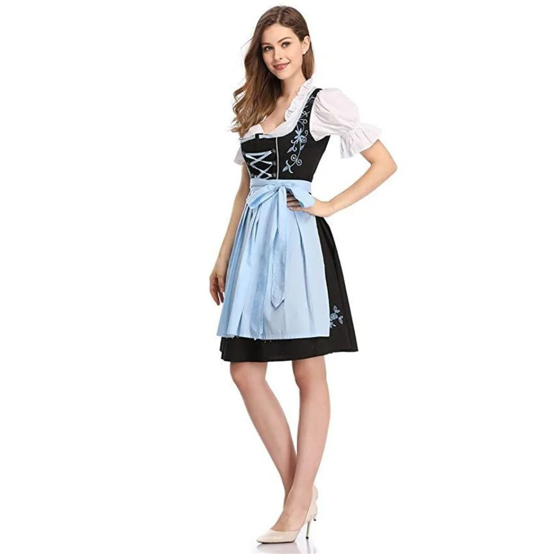 Frau in traditionellem bayerischen Dirndl mit blauer Schürze und weißer Bluse, Oktoberfest-Kleidung.