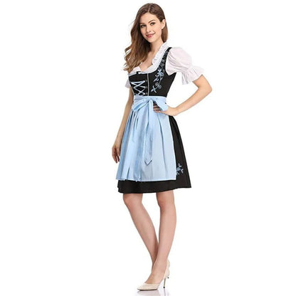 Frau in traditionellem bayerischen Dirndl mit blauer Schürze und weißer Bluse, Oktoberfest-Kleidung.