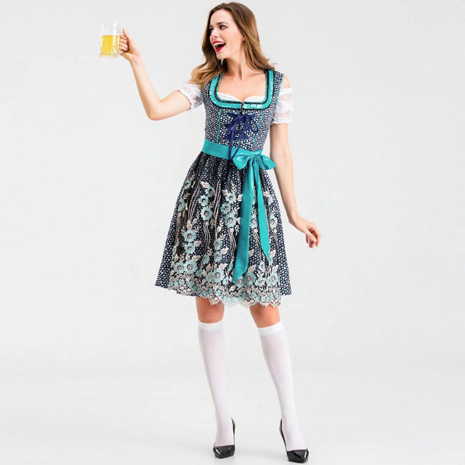 Frau im blauen Dirndl mit Blumenmuster, hält Bierkrug, Oktoberfest, traditionelle Tracht.