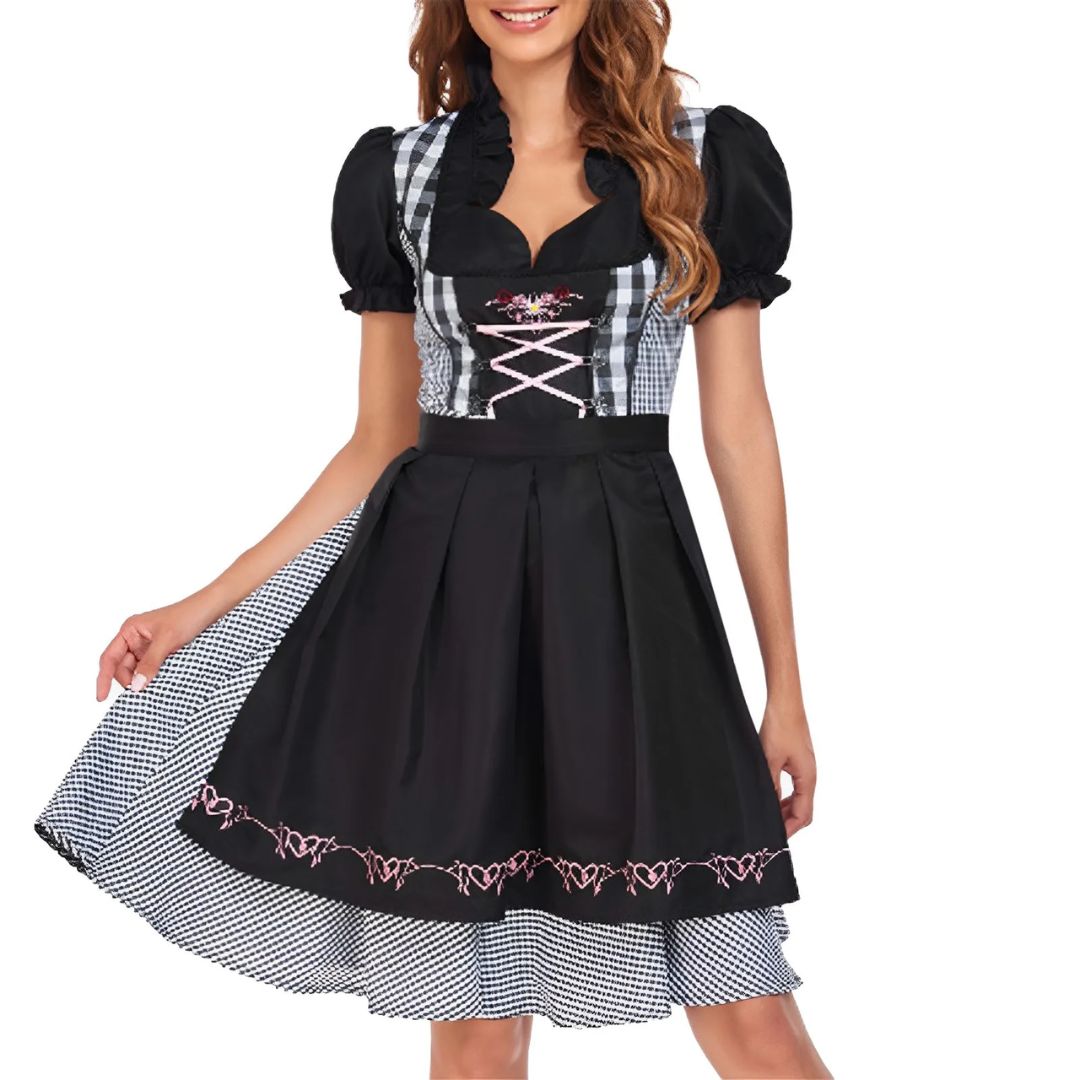 Frau im schwarz-weiß karierten Dirndl mit rosa Details, traditionelles bayerisches Kleid.