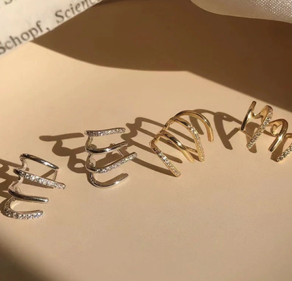 Goldene und silberne Ohrmanschetten mit Strasssteinen, modischer Schmuck, elegant und stilvoll.