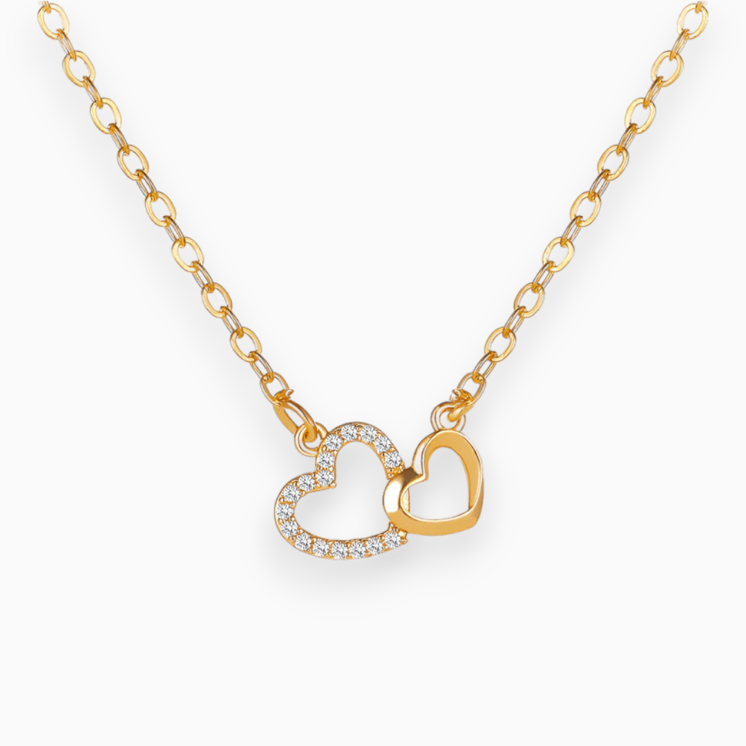 Goldene Halskette mit zwei Herzanhängern, einer mit Strasssteinen, eleganter Schmuck.
