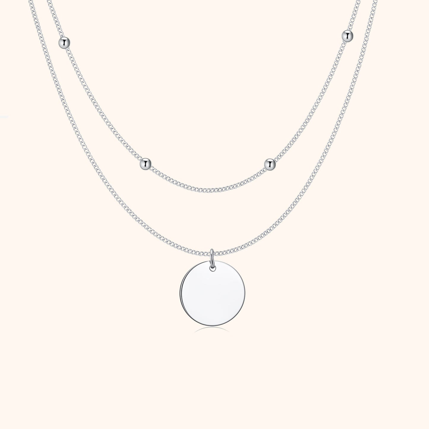 Silberne Halskette mit rundem Anhänger und kleinen Kugeln, elegantes Schmuckdesign.