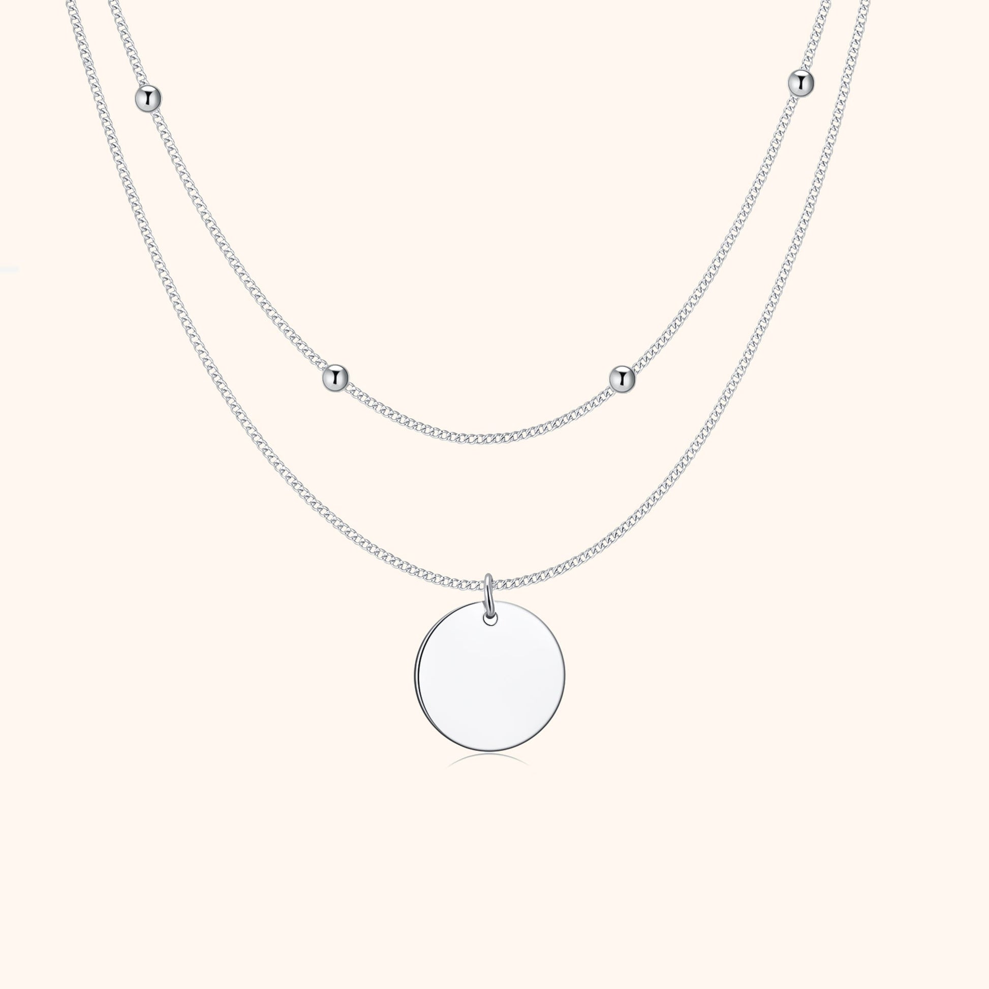 Silberne Halskette mit rundem Anhänger und kleinen Kugeln, elegantes Schmuckdesign.