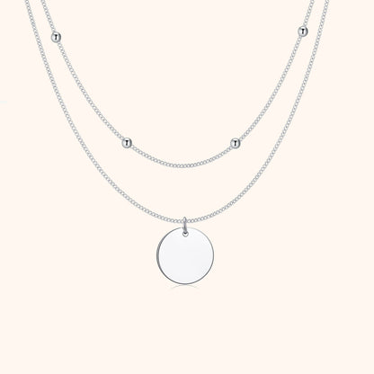 Silberne Halskette mit rundem Anhänger und kleinen Kugeln, elegantes Schmuckdesign.