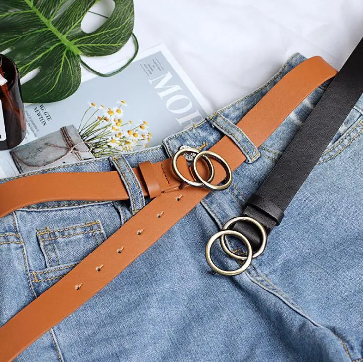 Doppelring-Designergürtel aus Leder in Braun und Schwarz auf Jeans, modisch, elegant.