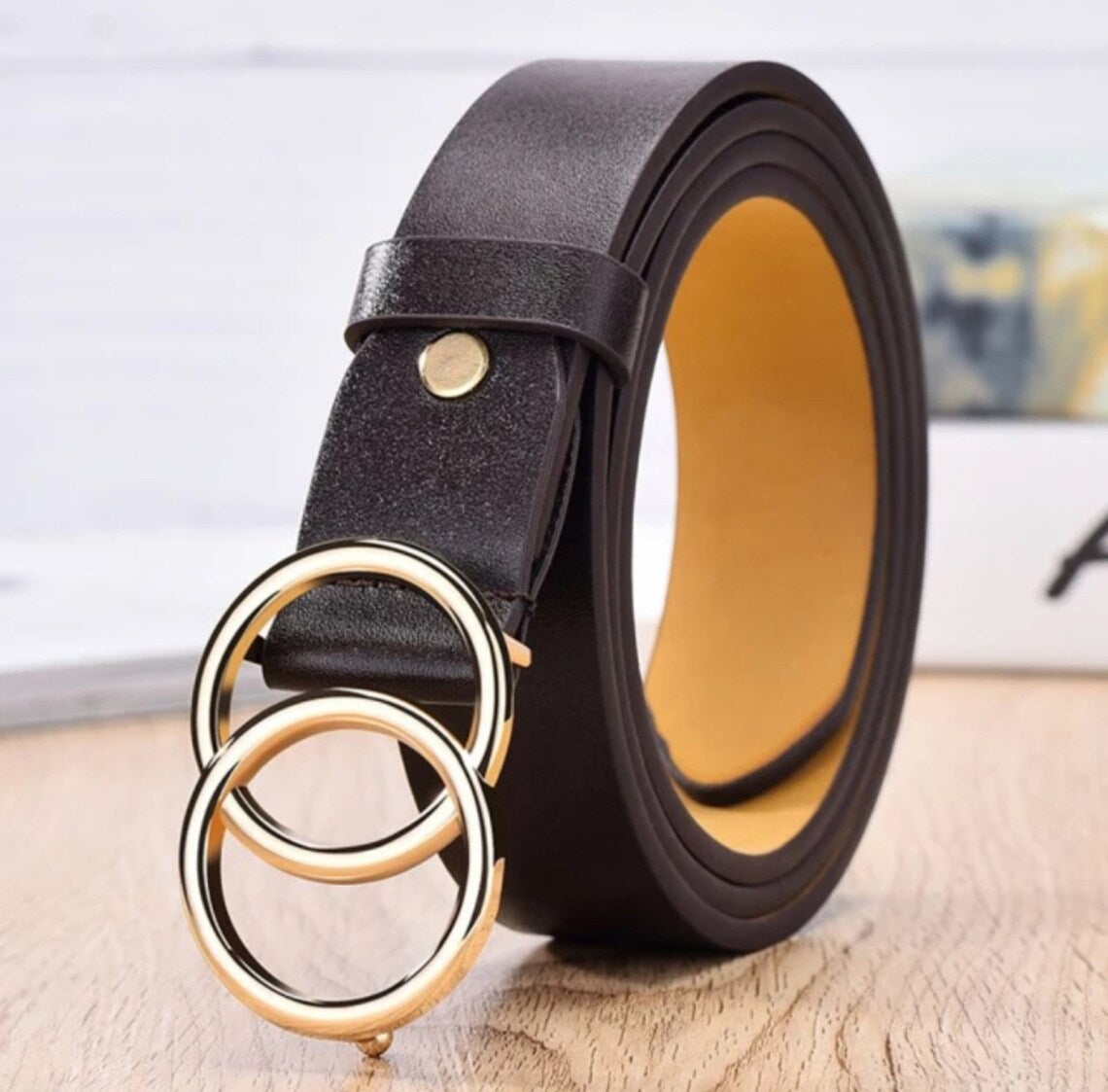 Doppelring-Designergürtel aus schwarzem Leder mit goldenen Schnallen, modisch und elegant.