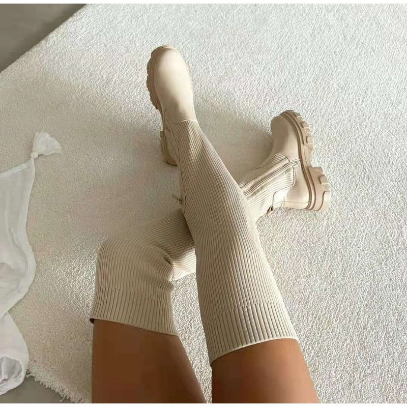 Beige kniehohe Stiefel, gerippt, auf Teppich, modisch, Damenmode, Herbst-Winter-Stil.