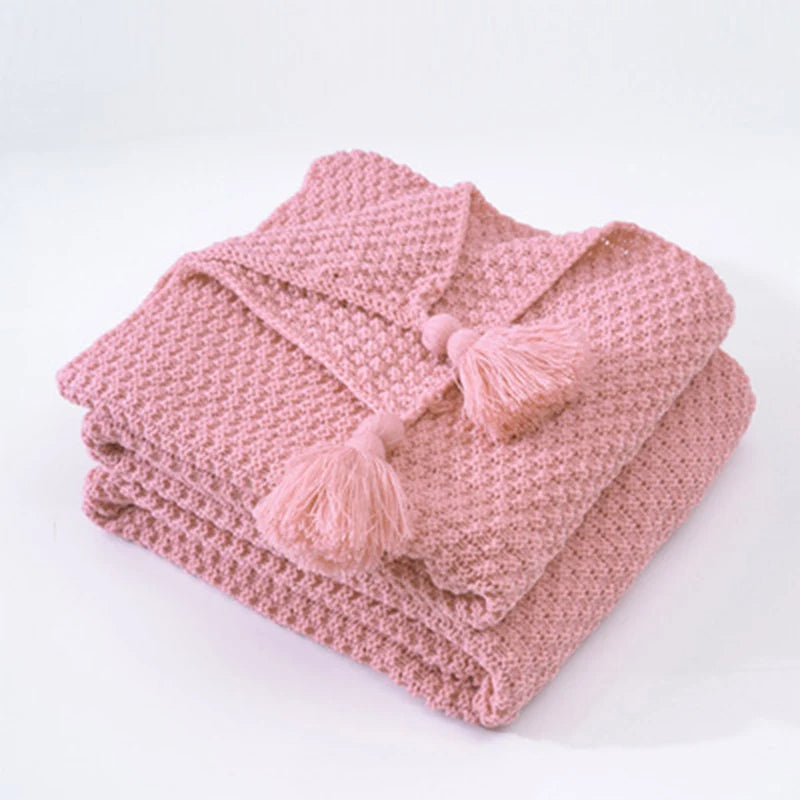 Rosa Strickdecke mit Quasten, weiches Baumwollmaterial, gemütliche Wohnaccessoires, modern.