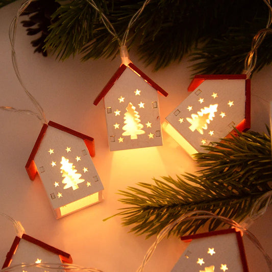 Weihnachtliche LED-Lichterkette mit Holzhaus-Design und Tannenbaum-Motiv, warmweiß leuchtend.