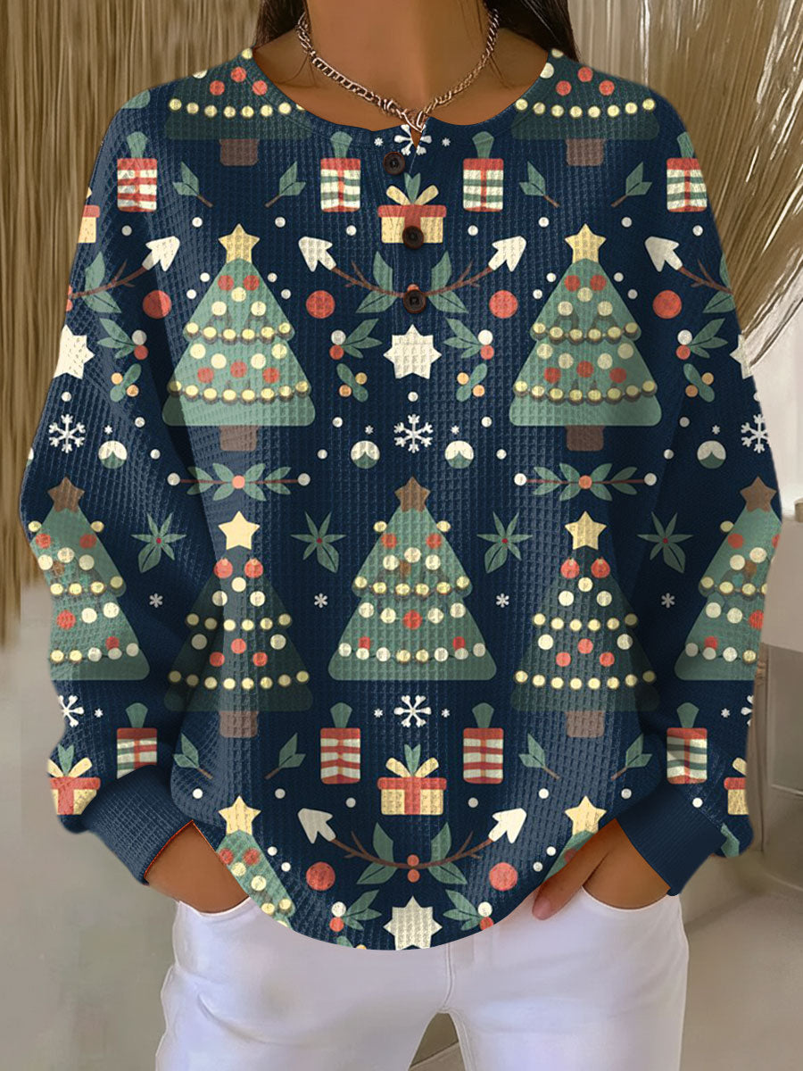 Mörkblå våffelstickad tröja med tryckta julgranar, presentpaket och snöflingor över hela framsidan. 8