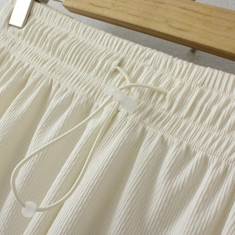 Weiße Baumwollhose mit Kordelzug, geripptes Design, lässige Damenmode, Nahaufnahme.