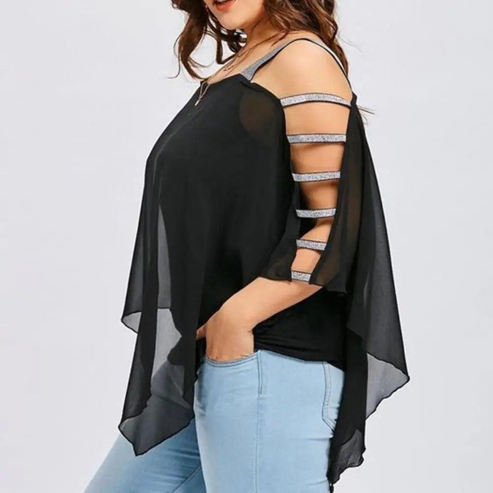 Frau in schwarzer Chiffon-Bluse mit Cut-Out-Ärmeln und blauer Jeans, modisch, elegant.