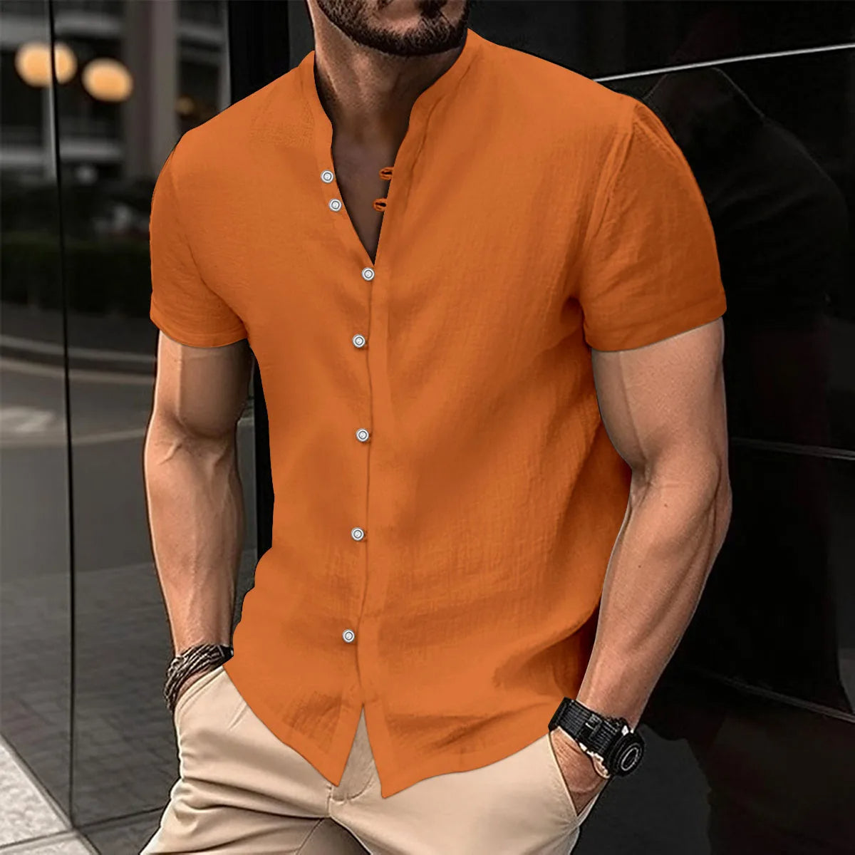 Mann in orangefarbenem Leinenhemd, kurzärmelig, mit Knopfleiste, modisch, urbaner Hintergrund.