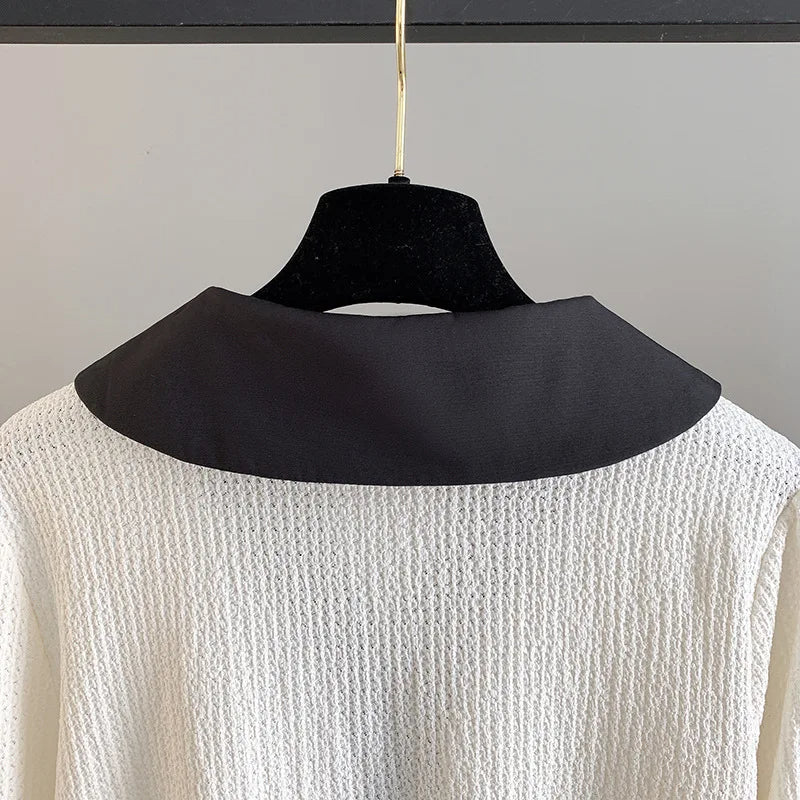 Schwarzer Kragen auf weißem Strickpullover, elegantes Design, modische Damenbekleidung.
