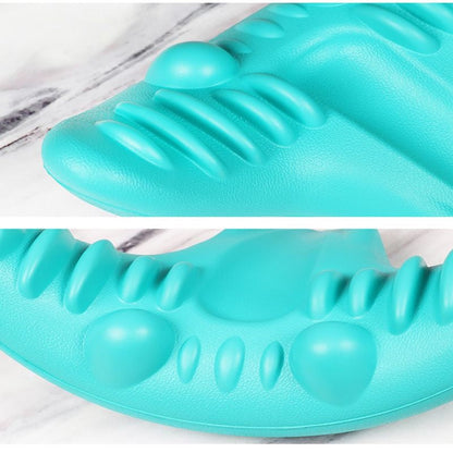 Türkises Massagegerät aus Kunststoff mit Noppen auf Marmorhintergrund.