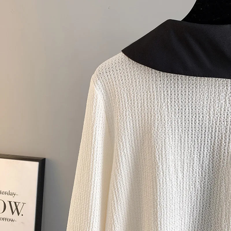 Weiße Strickjacke mit schwarzem Kragen, elegantes Design, hochwertige Damenmode.