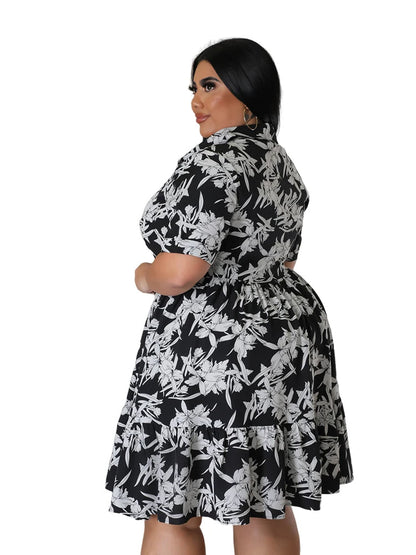 Frau in schwarz-weißem Blumenkleid, Plus-Size, Kurzarm, Rückansicht, Mode für Damen.