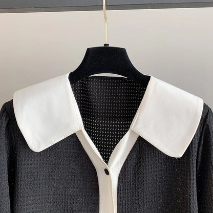 Schwarzes Kleid mit weißem Kragen, Knopfleiste, elegantes Design, Damenmode.