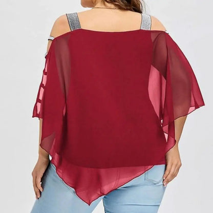 Frau in roter Chiffon-Bluse mit Cut-Out-Ärmeln und blauer Jeans von hinten.