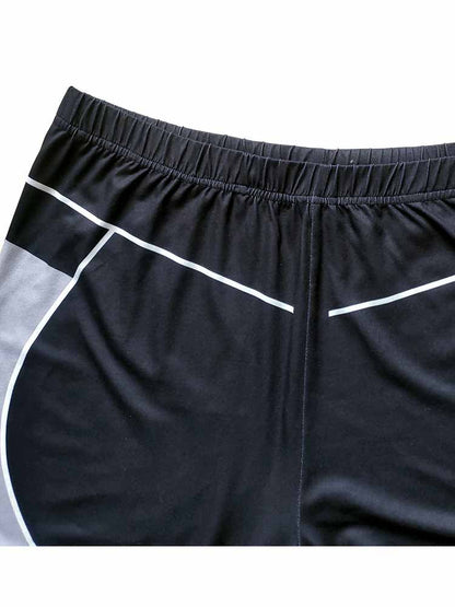 Schwarze Sportshorts mit weißen Streifen, elastischer Bund, atmungsaktives Material.