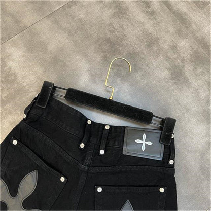 Schwarze Jeans mit Blumenmuster, Nieten, Kleiderbügel, modische Damenbekleidung.
